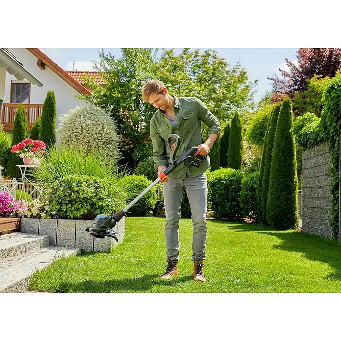 Gardena Power for All 18V Akku-Rasentrimmer ComfortCut - 18 V, Li-Ionen, Ohne Akku, Schnittbreite Messer: 23 cm - Ein Mann benutzt einen Gardena Akku-Trimmer zum Rasenkantenschneiden in einem gepflegten Garten.