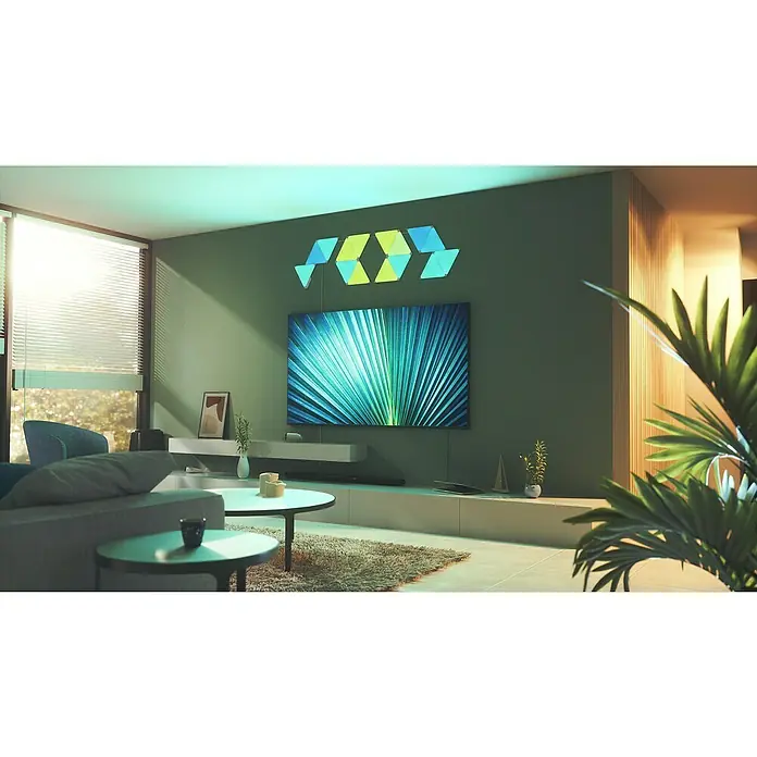 Nanoleaf Starterkit Shapes Triangles 15 Panels - 15 Stk., Weiß, RGBW, Triangles, Smart Home-fähig: Ja - Wohnzimmer mit Nanoleaf-Lichtern an der Wand, die eine stilvolle Atmosphäre schaffen und das moderne Design des Raumes ergänzen.