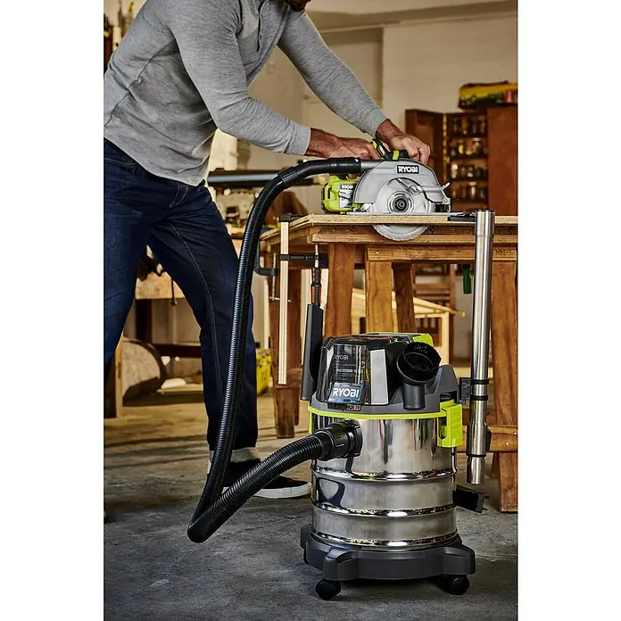 Ryobi ONE+ Akku-Nass-Trockensauger R18WDV-0 - 18 V, Ohne Akku, Behältervolumen: 18 l - Ein Mann bedient einen RYOBI-Kreissäge und einem RYOBI-Nass-/Trockensauger für staubfreies Sägen in einer Werkstatt.