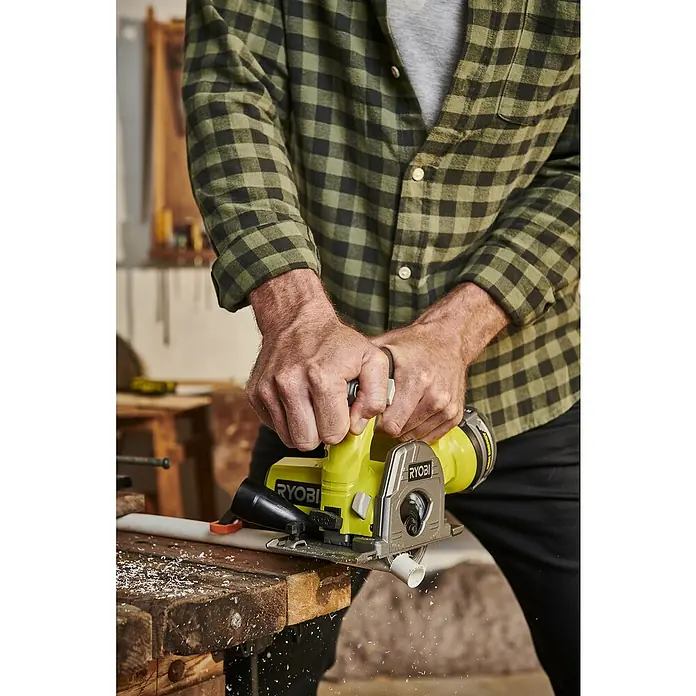 Ryobi ONE+ Maschinenpaket - Akku-Tauchsäge R18MMS-0 + gratis Starter-Kit - Ein Mann benutzt eine Ryobi Kreissäge, um ein PVC-Rohr zu schneiden. Ideal für Heimwerkerprojekte, die präzise Schnitte erfordern.