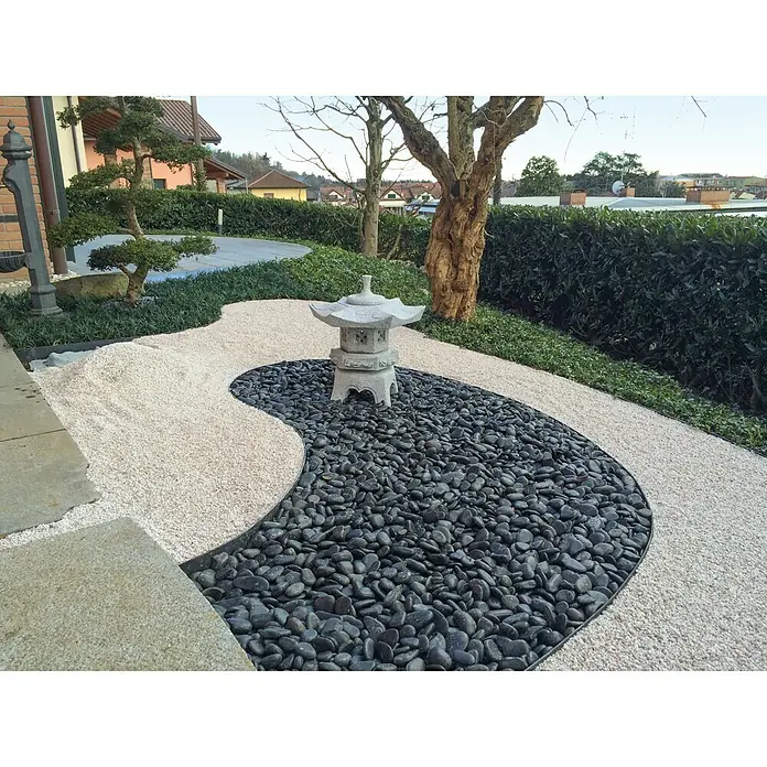 Marmorkiesel Nero Ebano - Schwarz/Anthrazit, Maße Stein: 10 - 20 cm, 15 kg - Eine friedliche Gartenszene mit einem japanischen Steinlaterne-Akzent, umgeben von schwarzen und weißen Kieselsteinen für einen harmonischen Look.