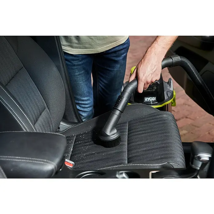 Ryobi ONE+ Akku-Nass-Trockensauger R18WDV-0 - 18 V, Ohne Akku, Behältervolumen: 18 l - Ein Mann reinigt einen Autositz mit einem RYOBI Staubsauger, um Schmutz und Ablagerungen zu entfernen.