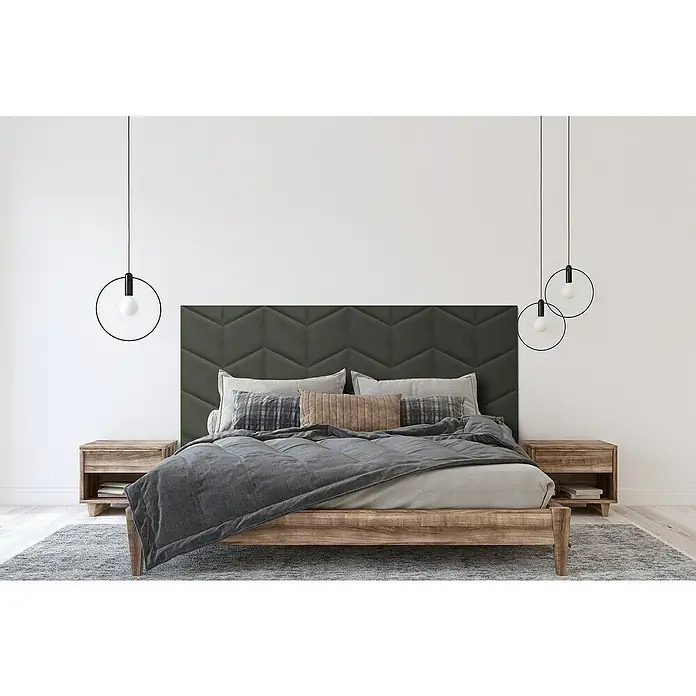 Fllow Panel de pared acolchado Velvet - Antracita, 45 x 30 cm, Características del diseño: Derecha - La imagen muestra un dormitorio elegante con un cabecero gris acolchado, mesitas de noche de madera y lámparas colgantes modernas.