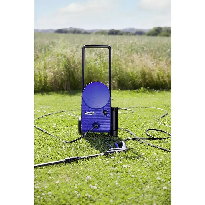Nilfisk Hidrolimpiadora de alta presión CORE 125 Home - 125 bar, 1.400 W, Capacidad de bombeo: 438 l/h - Vista superior de una hidrolimpiadora azul Nilfisk Core 125, colocada sobre un césped verde.