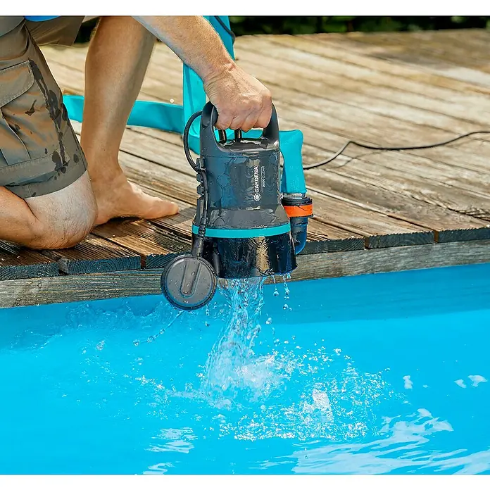 Gardena Klarwasser-Tauchpumpe 9000300 W, Max. Fördermenge: 9.000 l/h - Eine Gardena 9000 Clear Tauchpumpe wird in einen Pool gehalten, um Wasser abzupumpen. Ideal für sauberes oder leicht verschmutztes Wasser.