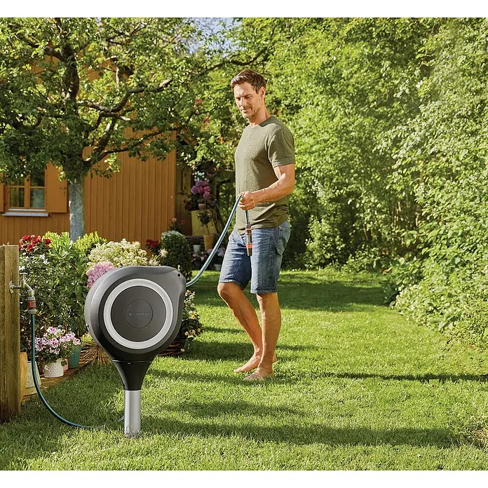 Gardena Schlauchbox RollUp M - Schlauchlänge: 20 m - Ein Mann benutzt eine Gardena Schlauchbox RollUp S zur Bewässerung seines Gartens. Sie ist kompakt, platzsparend und immer einsatzbereit.