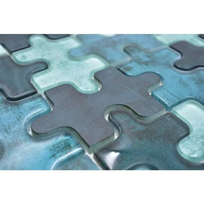 Mosaikfliese Puzzle Crystal Mix XCM PT03G - 29,8 x 29,8 cm, Grün, Glänzend - Nahaufnahme eines Puzzle mit blauen und grauen Teilen, die ein abstraktes Muster bilden und das Zusammenspiel von Form und Farbe betonen.