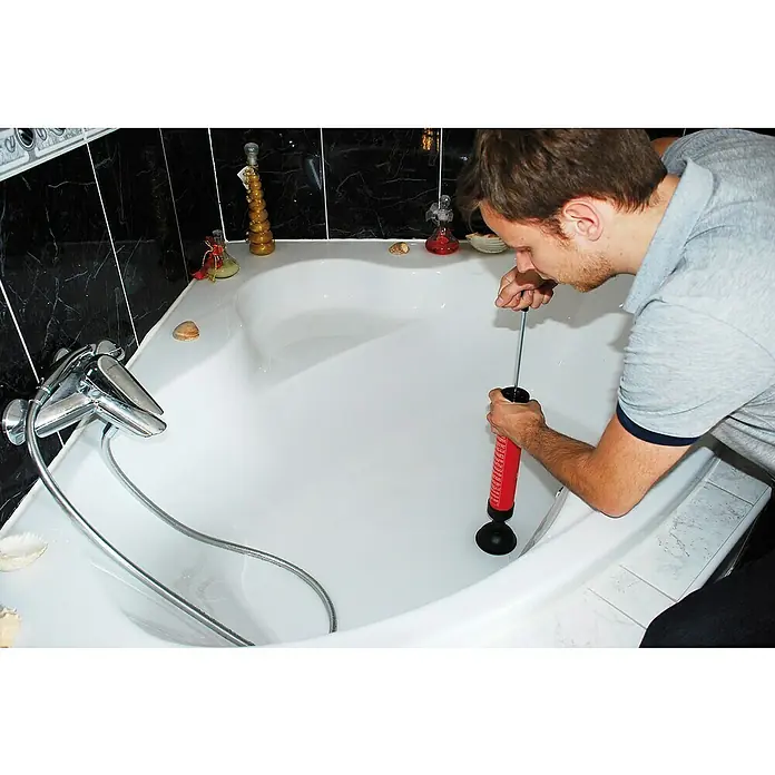 Rothenberger Industrial Abflusspumpe ROPUMP - Geeignet für: Abflüsse - Ein Mann benutzt einen Pömpel, um einen Abfluss in einer Badewanne freizumachen. Das Werkzeug ist rot und schwarz und scheint effektiv zu sein.