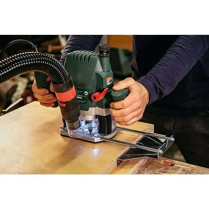 Bosch Oberfräse POF 1400 ACE - 1.400 W, 55 mm - Nahaufnahme einer Person, die mit einer Oberfräse auf einem Holzbrett arbeitet, um präzise Schnitte auszuführen.