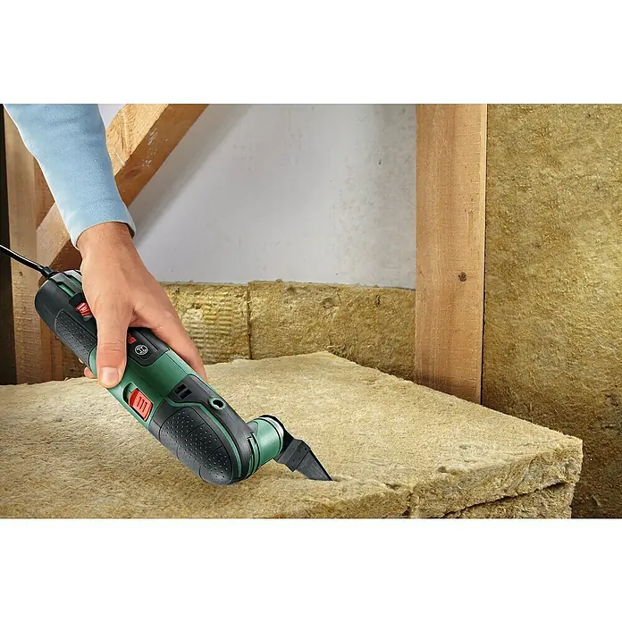 Bosch Elektro-Multifunktionswerkzeug PMF 220 CE - 220 W, STARLOCK-System - Nahaufnahme eines Bosch Multifunktionswerkzeugs, das in eine Steinwolleplatte schneidet, ideal für Bau- und Renovierungsprojekte.