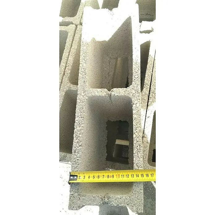 BHS Valencia Bloque de hormigón poroso - 50 x 15 x 20 cm, Hormigón - Bloque de hormigón con tres agujeros y una cinta métrica para indicación del tamaño. El bloque de hormigón es gris y tiene una superficie rugosa.
