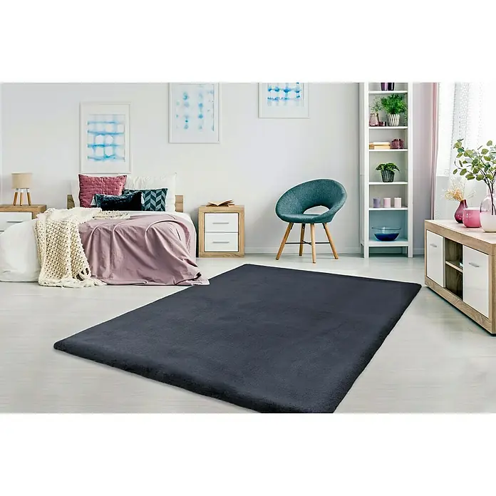Fellteppich Happy - Graphit, 150 x 80 cm, 100 % Polyester (Flor) - Ein weicher, dunkelgrauer Teppich liegt in einem hellen Schlafzimmer und sorgt für Wärme und Komfort unter den Füßen.