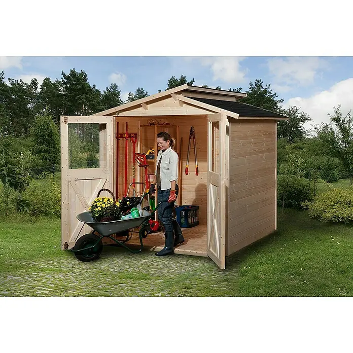 Weka Gartenhaus 323 - Außenmaß inkl. Dachüberstand (B x T): 290 x 217 cm, Holz, Natur, 4,928 m² - Die Frau im Gartenhaus mit Schubkarre, gefüllt mit Blumen. Das Holzgartenhaus bietet viel Stauraum für Gartengeräte und Zubehör.