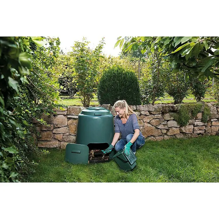 Garantia Komposter - 280 l, Ø x H: 80 x 89 cm - Frau arbeitet mit einem grünen Kompostbehälter im Garten, der zur Kompostierung von Gartenabfällen dient.