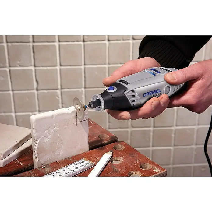 Dremel Multifunktionswerkzeug 3000-15 - 130 W - Nahaufnahme des Dremel 3000 beim Schneiden einer Fliese, ideal für Heimwerkerprojekte.