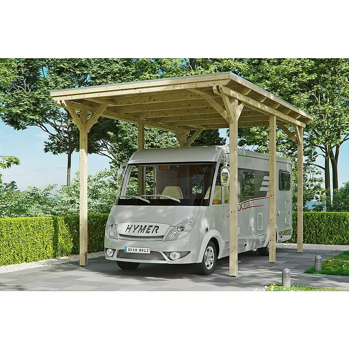 Skan Holz Carport EmslandAußenmaß inkl. Dachüberstand (B x T): 4,04 x 6,04 m, Einzelcarport, Carport geeignet für: Caravans, Natur - Ein graues Wohnmobil, geparkt unter einem hellen Holzunterstand, umgeben von Grünpflanzen.