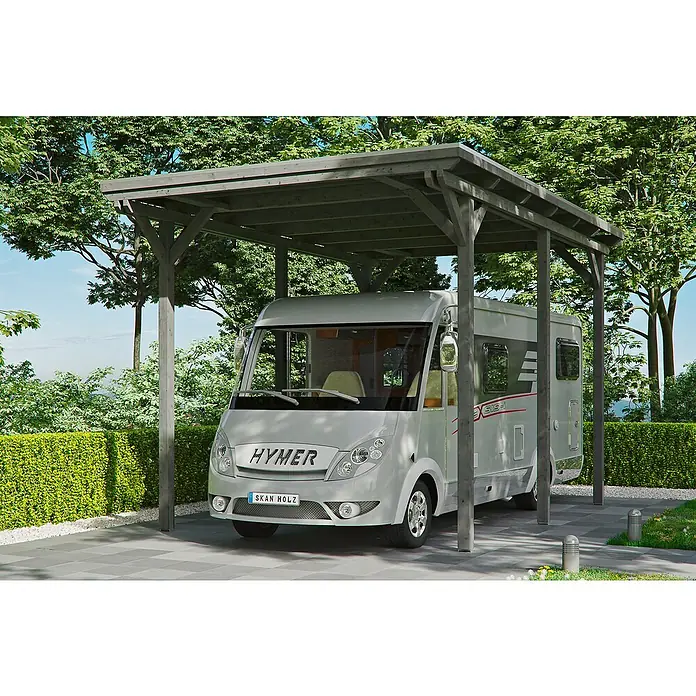 Skan Holz Carport EmslandAußenmaß inkl. Dachüberstand (B x T): 4,04 x 6,04 m, Einzelcarport, Carport geeignet für: Caravans, Schiefergrau - Das Bild zeigt ein graues Holzcarport mit einem Hymer-Wohnmobil darunter, umgeben von üppigem Grün und einem gepflasterten Bereich.