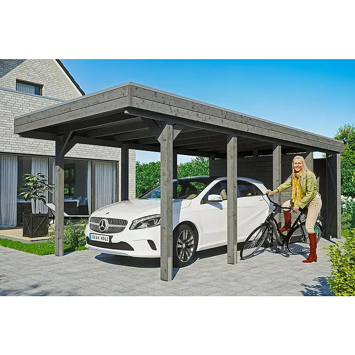 SKAN HOLZ Carport Friesland - Außenmaß inkl. Dachüberstand (B x T): 3,14 x 7,08 m, Einzelcarport, Schiefergrau - Ein modernes Carport aus Holz mit einem weißen Auto darunter und einer Frau mit Fahrrad. Das Carport bietet Schutz und wertet das Grundstück auf.
