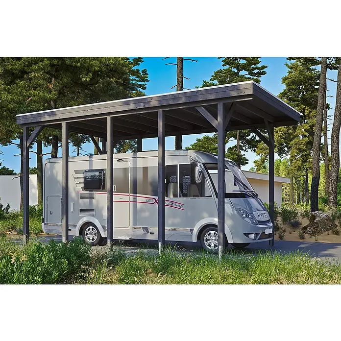 SKAN HOLZ Carport Friesland - Außenmaß inkl. Dachüberstand (B x T): 3,97 x 7,08 m, Einzelcarport, Schiefergrau - Ein graues Wohnmobil steht unter einem dunklen Holzcarport, umgeben von grüner Vegetation, was eine ruhige und funktionale Szene ergibt.