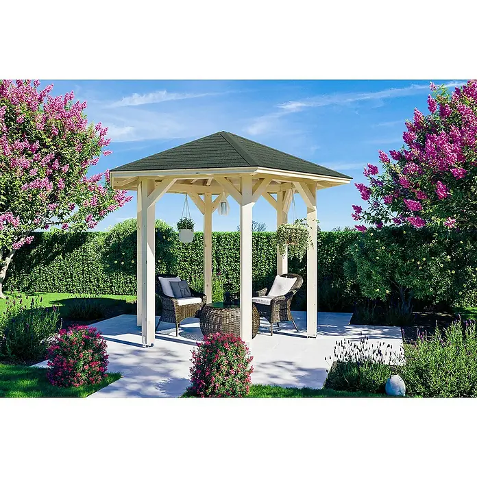 SKAN HOLZ Pavillon Nancy 1 - L x B: 312 x 360 cm, Natur - Eine Gartenlaube mit dunkelgrünem Dach, umgeben von blühenden Sträuchern und grünen Hecken, bietet einen gemütlichen Sitzbereich mit Rattanmöbeln.
