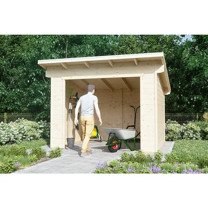 SKAN HOLZ Holzunterstand Ole - 250 x 300 x 249,5 cm, Natur - Ein helles Gartenhaus mit Werkzeug und einer Schubkarre darin, umgeben von üppigem Grün und Blumen. Eine Person betritt das Häuschen.