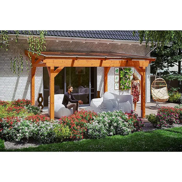 Skan Holz Terrassenüberdachung SanremoB x T: 434 x 300 cm, Eiche Hell, Fichtenholz - Entspannter Mann unter einer Holzpergola mit transparentem Dach, umgeben von blühenden Blumen und einer schaukelnden Hängematte.