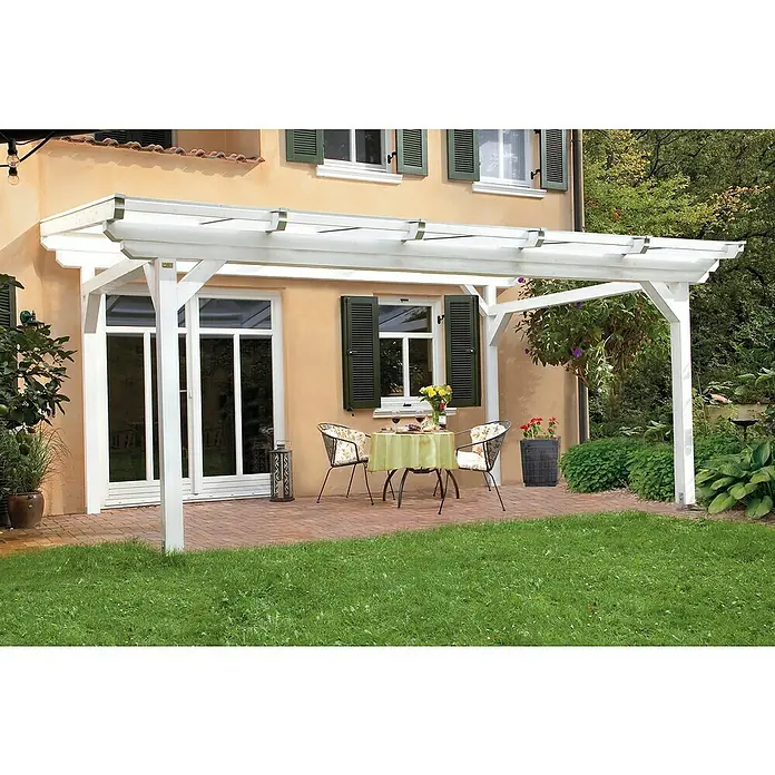 SKAN HOLZ Terrassenüberdachung Sanremo - B x T: 648 x 400 cm, Weiß, Fichtenholz - Eine weiße Pergola über einer Terrasse mit Tisch und Stühlen vor einem Haus mit grünen Fensterläden bietet ein schattiges Plätzchen im Freien.