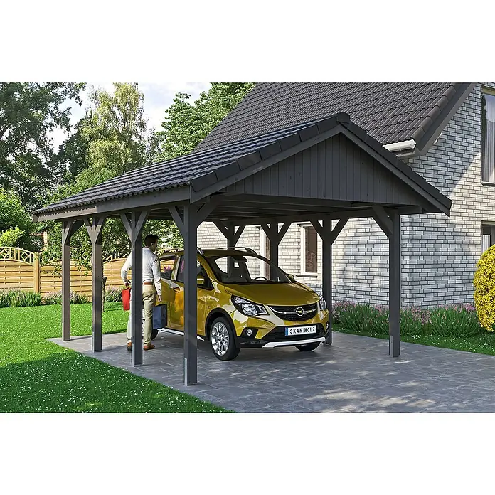 SKAN HOLZ Carport Wallgau - Außenmaß inkl. Dachüberstand (B x T): 4,3 x 6 m, Einzelcarport, Schiefergrau, Dachlatten zur Eindeckung mit Dachziegeln - Ein modernes Carport aus Holz bietet Schutz für ein gelbes Auto. Eine Person steht daneben, im Hintergrund ein Haus mit Ziegelmauer.