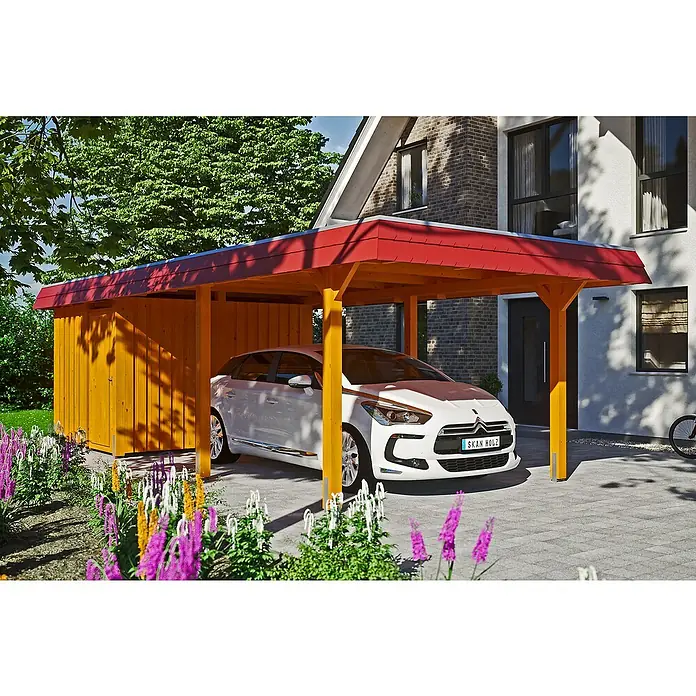 SKAN HOLZ Carport Wendland - Außenmaß inkl. Dachüberstand (B x T): 3,62 x 8,7 m, Einzelcarport, Eiche Hell, Farbe Dach: Rot, Materialspezifizierung Dach: EPDM-Folie, Fichte, Mit Abstellraum - Carport aus Holz mit rotem Dach, unter dem ein weißes Auto steht. Daneben befindet sich ein Geräteschuppen, umgeben von bunten Blumen.