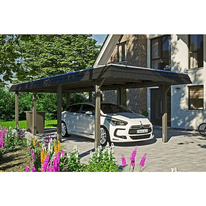 SKAN HOLZ Carport Wendland - Außenmaß inkl. Dachüberstand (B x T): 3,62 x 8,7 m, Einzelcarport, Schiefergrau, Farbe Dach: Anthrazit, Dachschalung mit EPDM-Folie - Das Bild zeigt einen modernen, dunkelgrauen SKAN HOLZ Carport mit einem weißen Auto darunter, umgeben von Blumen und einem Haus.