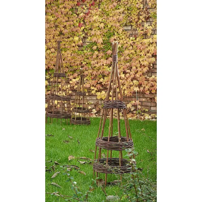 Rankhilfe - Höhe: 110 cm, Weide, Naturbraun - Drei dekorative Weidenobelisken stehen im Garten auf dem Rasen, ideal als Rankhilfe und Gartendekoration.