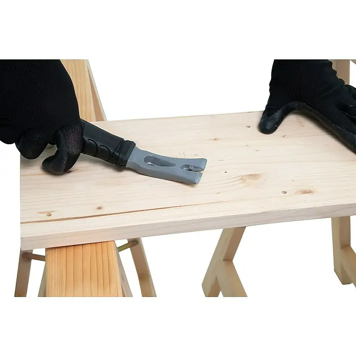 Wisent Abbruchwerkzeug - 380 mm, AHS-Stahl - Ein Handwerker entfernt Nägel mit einem Brecheisen von einem hellen Holzbrett, das auf zwei Böcken liegt.