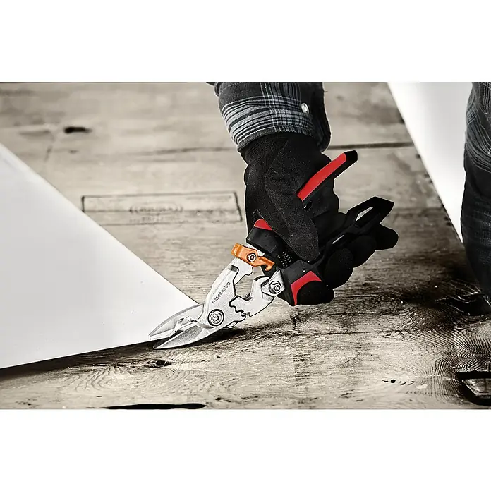 Fiskars PowerGear Blechschere - Länge: 29 cm, Schnittlänge: 38,1 mm, Rechtsschneidend, Schwarz/Rot - Eine Hand in einem Handschuh schneidet ein Stück Material mit einer Fiskars Mehrzweckschere, die für verschiedene Schneidaufgaben geeignet ist.