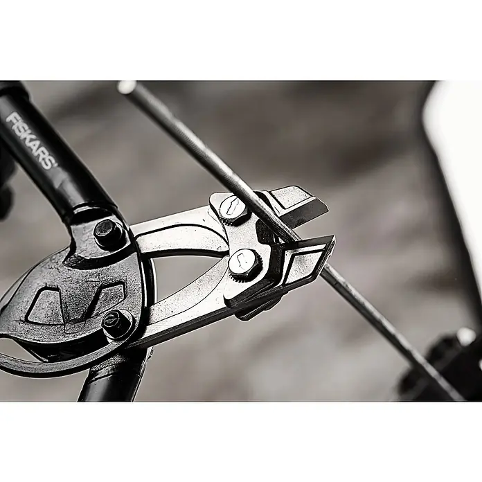 Fiskars PowerGear Bolzenschneider - Länge: 35,5 cm, Schwarz - Nahaufnahme einer Drahtschere der Marke Fiskars, die einen Metalldraht durchtrennt. Das Werkzeug ist auf Funktionalität ausgelegt.