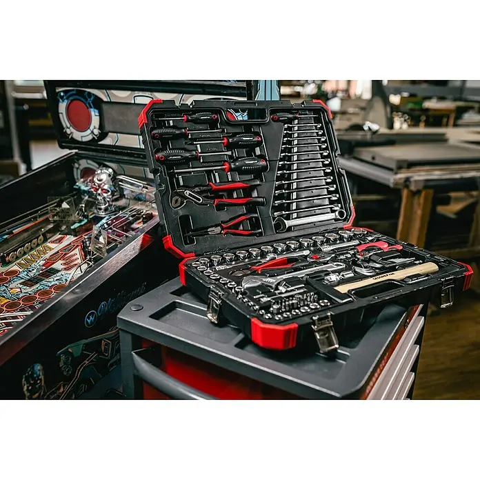 Gedore red Steckschlüssel-Set - 100 -tlg., Antriebsgröße: ½″ - Werkzeugkoffer mit rotem Akzent, gefüllt mit verschiedenen Werkzeugen, auf einem grauen Werkzeugwagen.