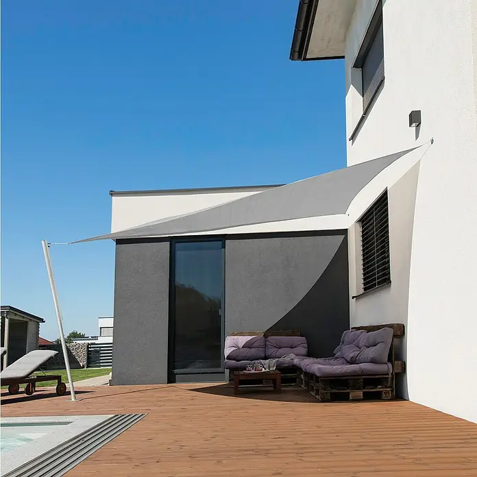 Windhager Sonnensegel Capri - L x B: 5 x 5 m, Grau, Dreieckig - Sonnensegel über einer Holzterrasse mit Loungemöbeln, das Schatten spendet und einen modernen Akzent setzt.