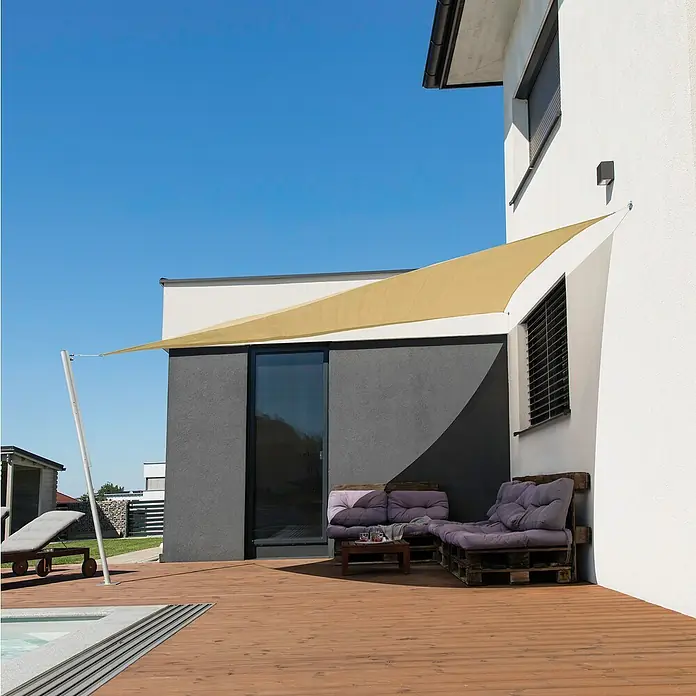 Windhager Sonnensegel Elba - L x B: 3,6 x 3,6 m, Ivory, Dreieckig - Bild einer dreieckigen, beigen Sonnensegelanlage, die Schatten auf einer Holzterrasse vor einem modernen Haus spendet.