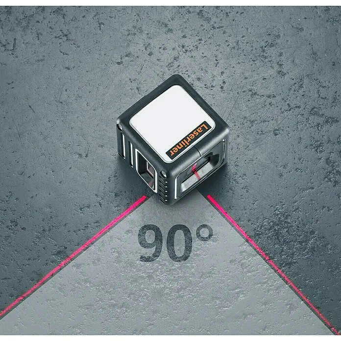 Laserliner Kreuzlinienlaser CompactCube 3 - Max. Arbeitsbereich: 15 m - Würfelförmiger Laserliner-Winkelmesser, der rote Laserlinien projiziert, um einen 90-Grad-Winkel zu erzeugen, auf einer grauen Oberfläche.