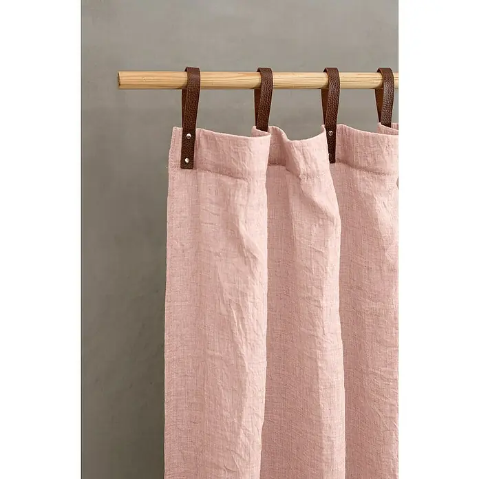Schlaufenschal Evi - 80 % Polyester, 20 % Baumwolle, Altrosa - Nahaufnahme von zartrosa Vorhängen mit Lederlaschenaufhängung an einer hellen Holzstange vor einem grauen Hintergrund.