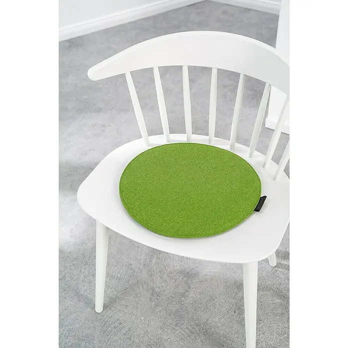 Sitzkissen rund Carl - Ø x H: 35 x 2 cm, Grün, 100 % Polyester - Ein grünes Sitzkissen auf einem weißen Stuhl. Das Sitzkissen ist rund und besteht aus Filz, was für zusätzlichen Komfort sorgt.
