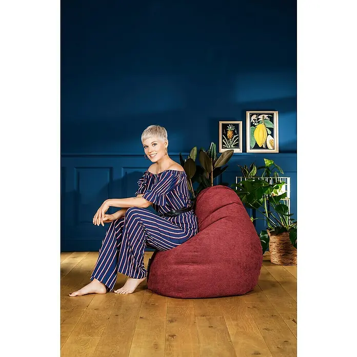 Sitting Point Sitzsack Beanbag Alfa - XXL, Weinrot, 100 % Polyester - Eine Frau im gestreiften Jumpsuit sitzt auf einem weinroten Sitzsack. Das gemütliche Möbelstück lädt zum Entspannen in jedem Wohnraum ein.