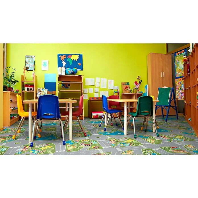 Tarkett Moqueta a metros Rompecabezas - Ancho: 2 m, Poliamida, Multicolor - Colorida aula de jardín de infancia con mesas, sillas, estantes y una alfombra de juego con un motivo de ciudad, ideal para jugar y aprender.