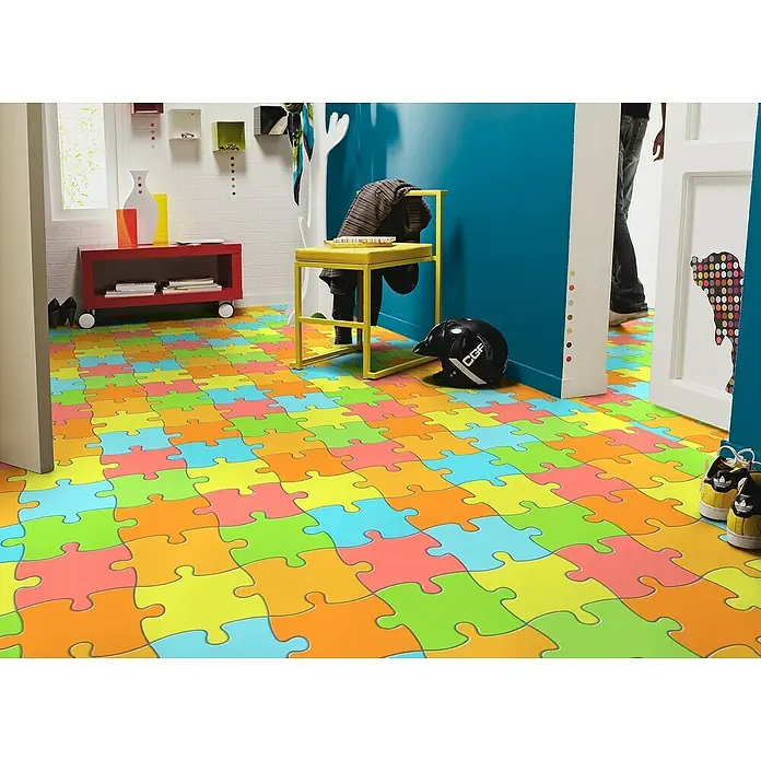 Tarkett Moqueta a metros Rompecabezas - Ancho: 2 m, Poliamida, Multicolor - Una habitación colorida con suelos de rompecabezas, una estantería roja, un taburete amarillo y varios accesorios.