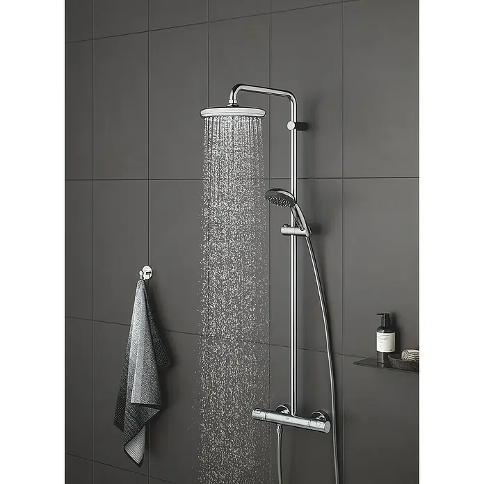 Grohe Vitalio Start Handbrause 100 - Anzahl Funktionen: 2 Stk., Durchmesser: 10 cm, Chrom - Aufnahme einer modernen Dusche mit Chromoberfläche vor grau gefliestem Hintergrund.