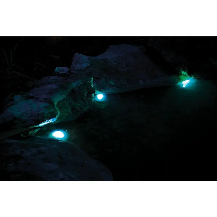 Pontec Teichbeleuchtung PondoStar LED - 3 Stk., Lichtfarbe: RGB - Blaue Unterwasserleuchten erhellen einen dunklen Teich mit Steinen, wodurch eine geheimnisvolle und beruhigende Atmosphäre entsteht.