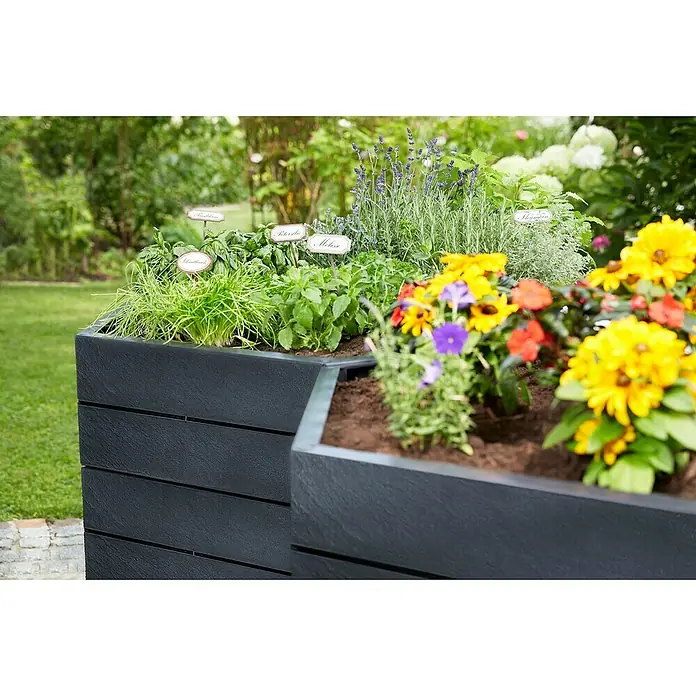 Garantia Hochbeet Ergo XL Stone SetØ x H: 145 x 75 cm, Kunststoff, Anthrazit - Hochbeet aus dunklem Holz mit frischen Kräutern und bunten Blumen, ideal für Garten und Balkon, mit Kräuterschildern versehen.