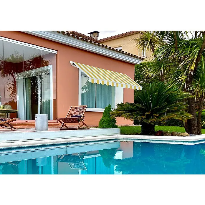 SmartSun Toldo de brazos extensibles Sunbasic - Amarillo/Blanco, Ancho: 2,5 m, Caída: 2 m - Casa con toldo de rayas amarillas y blancas sobre la ventana, que proporciona sombra y realza la estética del edificio.