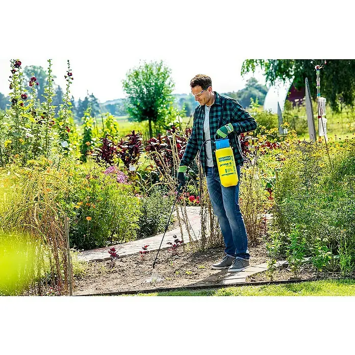 Gloria Drucksprühgerät Prima 5 PLUS - 5 l - Ein Mann verwendet eine gelbe Gloria Prima 5 Plus Druckspritze im Garten, um Pflanzen zu behandeln, Schutzbrille und Handschuhe inklusive.