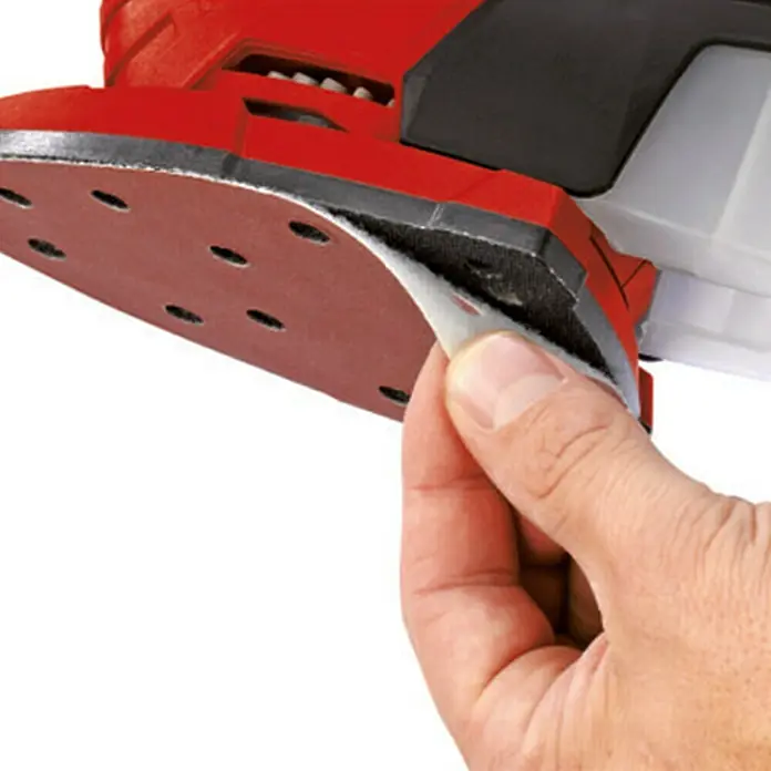 Einhell PXC 18V Multilijadora de batería TE-OS 18/150 Li - Solo - 18 V, Sin batería, Iones de litio, 24.000 r.p.m. - Primer plano de una lijadora con carcasa roja, donde se está reemplazando papel de lija.