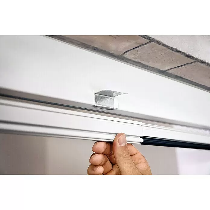 Tesa Insect Stop Puerta con protección contra insectos Falt - Blanco, Montaje de la mosquitera: Pinzas - Mano instalando perfil blanco en soporte metálico plateado.